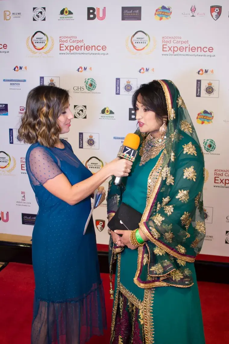 A guest being interviewed in front of the Red Carpet Experience backdrop